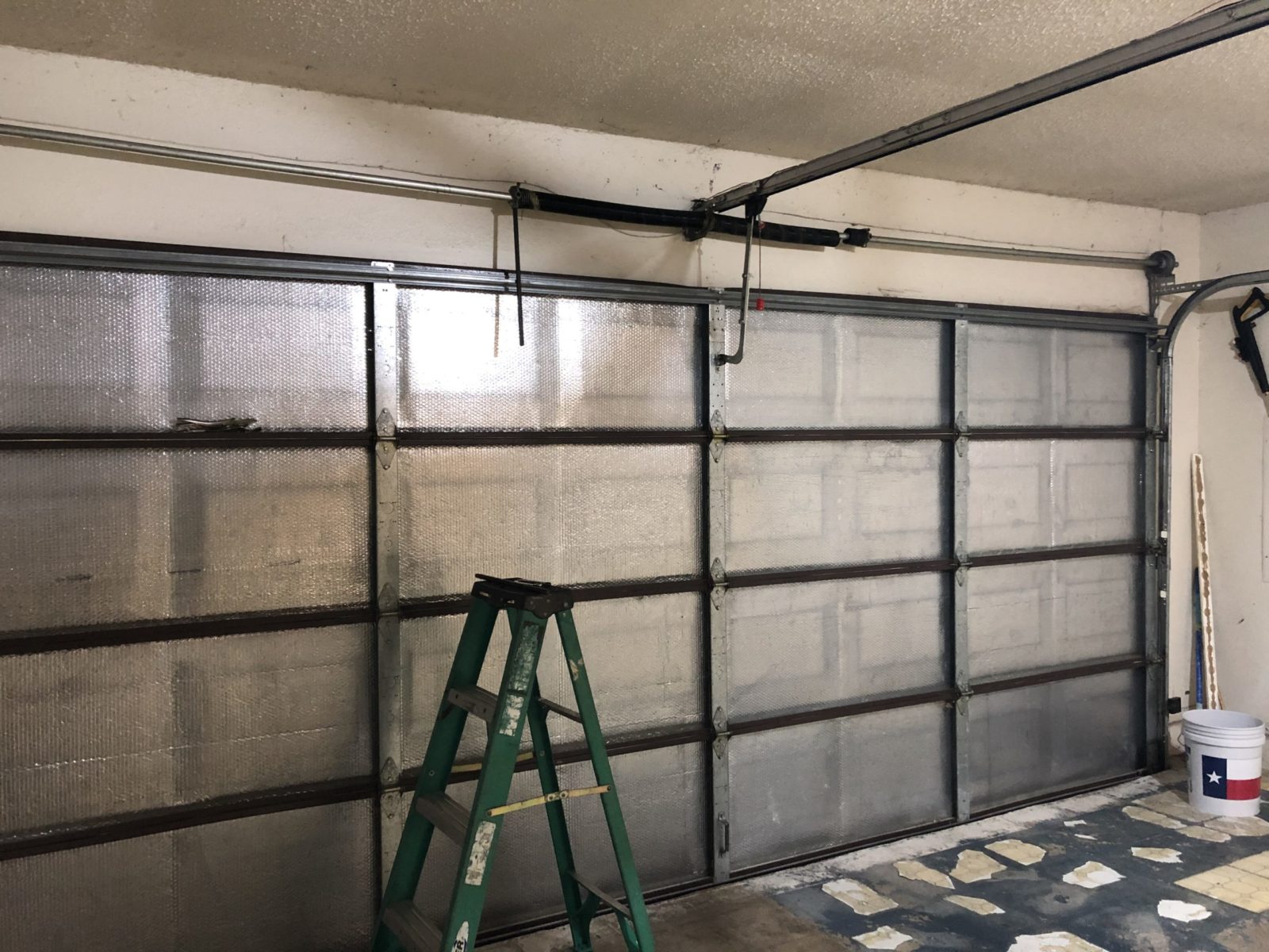 Insulated garage door with thermal panels for energy efficiency